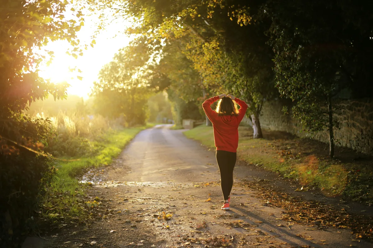 Woman walking along a sunlit country path